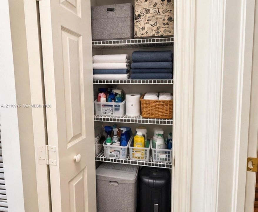 Storage closet featuring multi-tiered wire shelving and double-panel doors