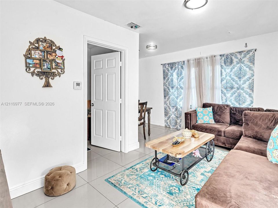Large-format tile flooring, flush-mount ceiling lighting, and a multi-panel interior door