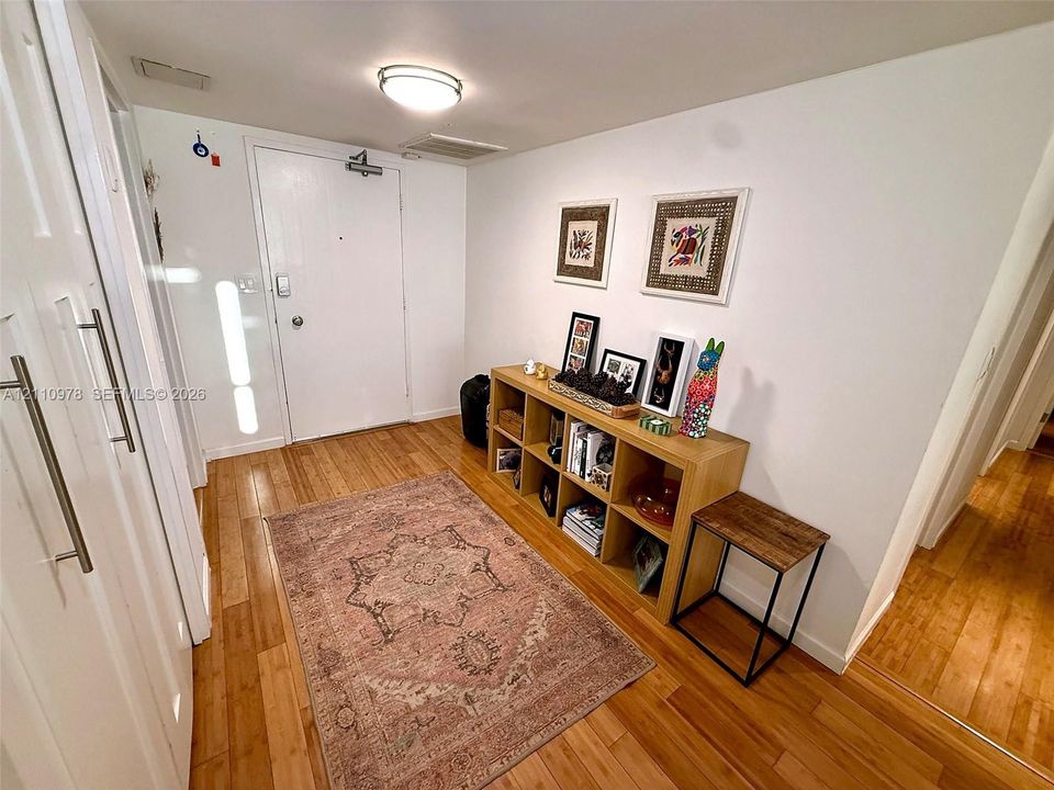 Entryway featuring wood-finish flooring, white walls, and a recessed ceiling light fixture