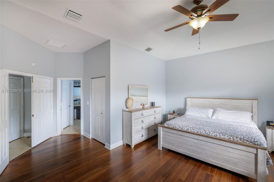 Vaulted ceilings, wood-finish flooring, and a ceiling fan with integrated lighting