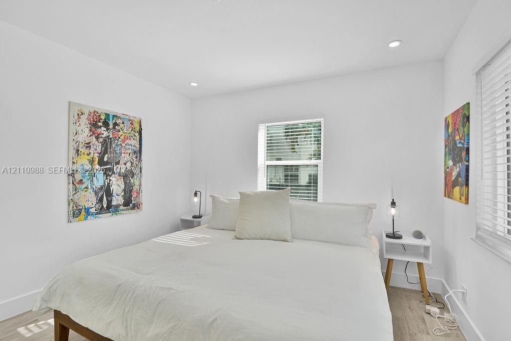 Neutral interior featuring light-tone wood-finish flooring, recessed lighting, and horizontal window blinds