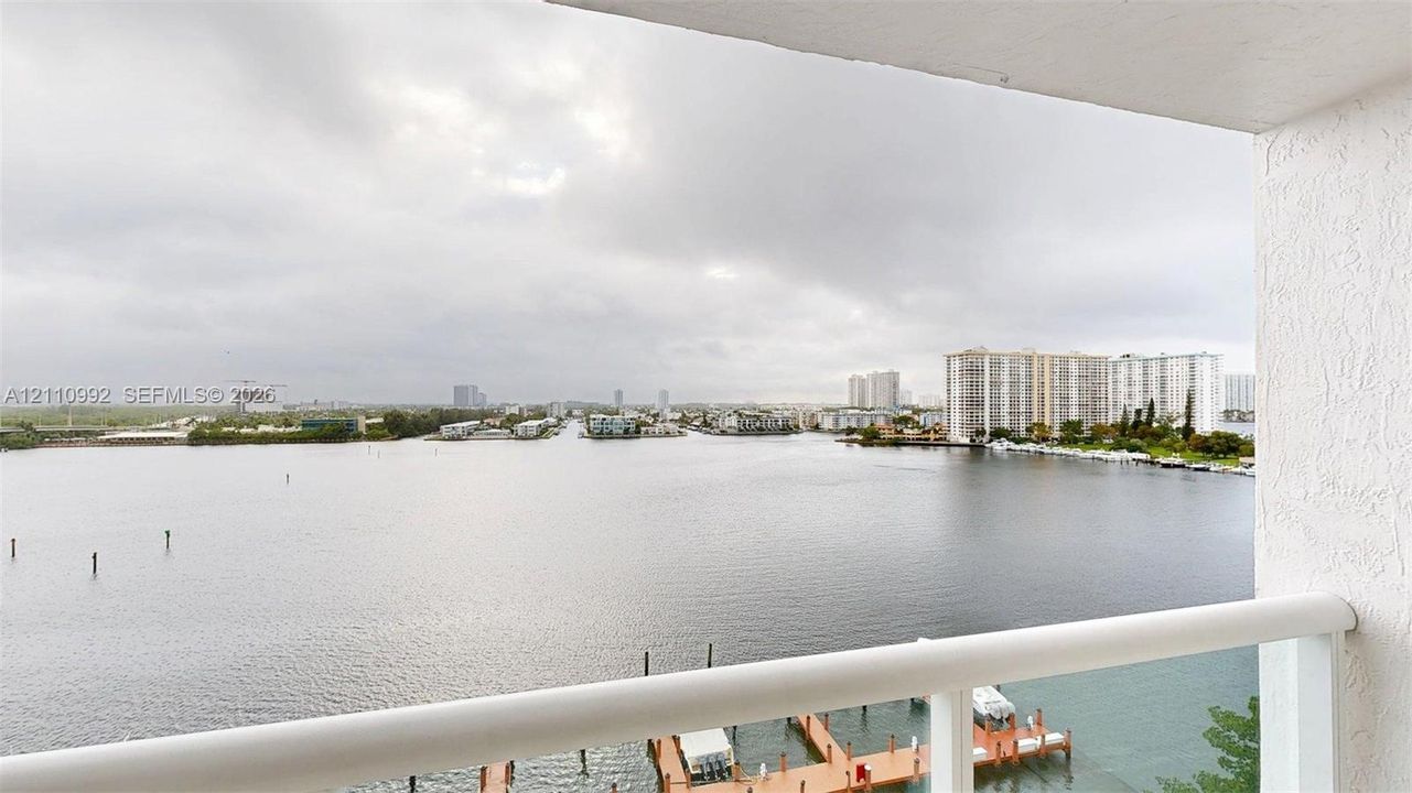 Covered balcony featuring white structural railings and direct water frontage