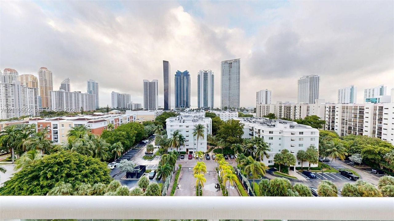 Elevated balcony featuring a white railing and expansive skyline scenery