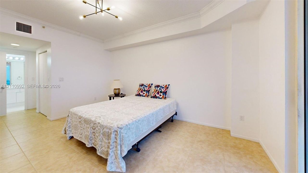 Neutral interior featuring tile flooring, crown molding, and a modern multi-arm ceiling light fixture