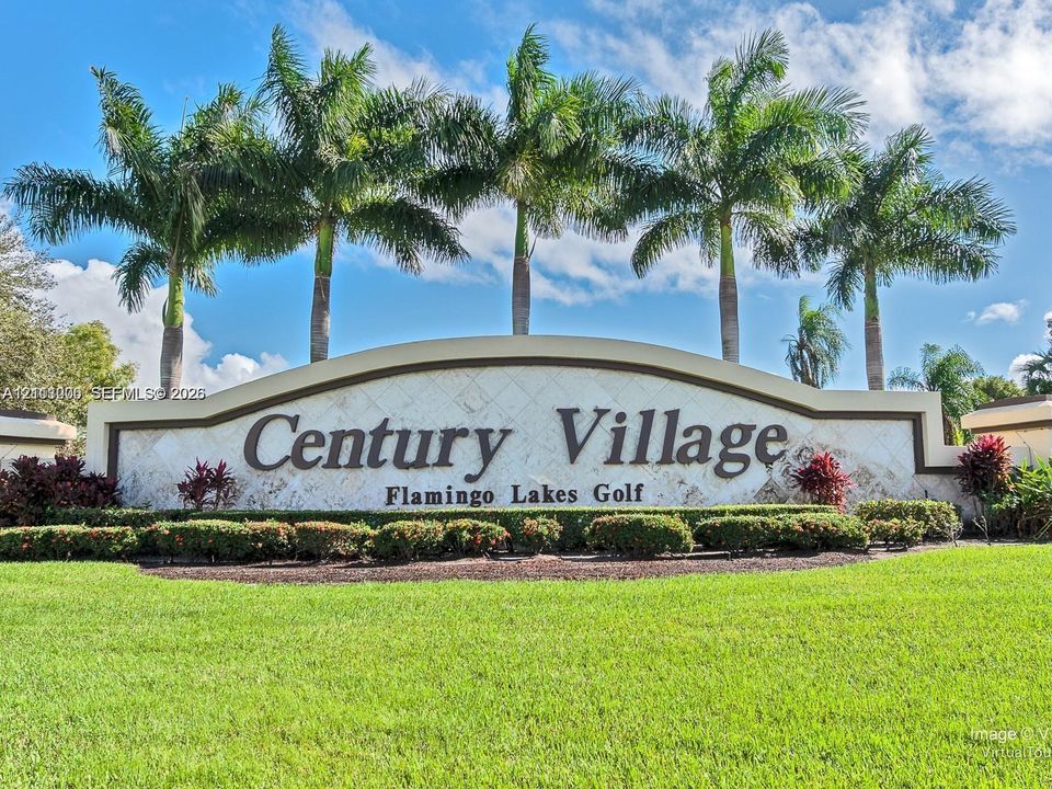 Stone-clad community entrance signage featuring mature palm trees, professional landscaping, and manicured turf