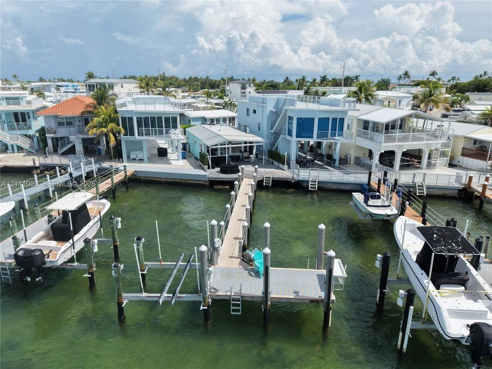 Waterfront property featuring private docks, multi-level exterior balconies, and concrete bulkhead seawall