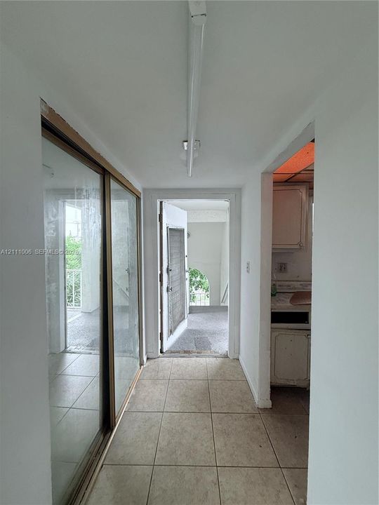 Ceramic tile flooring, sliding glass door, and linear ceiling-mounted lighting