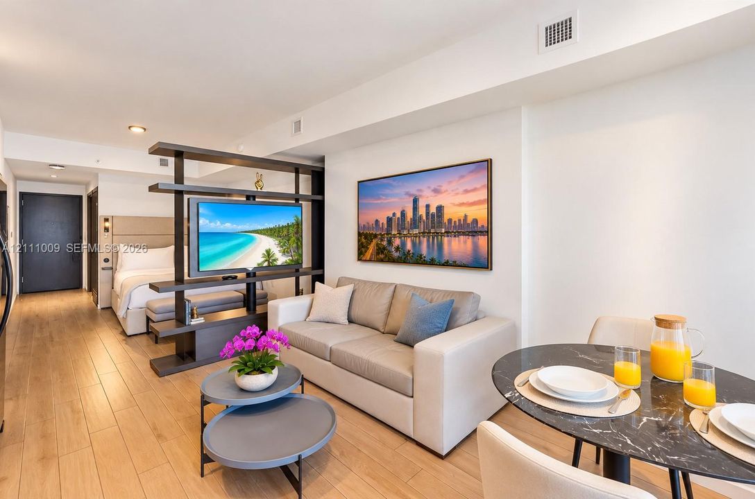 Open-concept floor plan featuring wood-finish flooring, recessed lighting, and a floor-to-ceiling built-in shelving partition