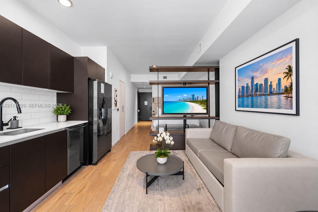 Kitchen featuring dark cabinetry, white countertops, a subway tile backsplash, and wood-finish flooring