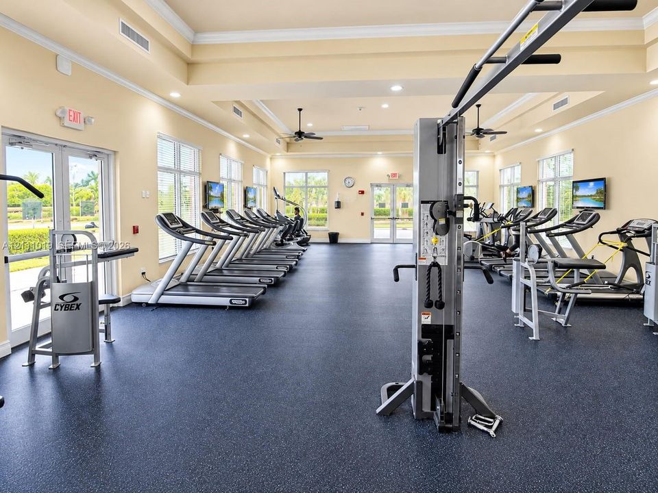 Fitness facility featuring high ceilings with crown molding, recessed lighting, ceiling fans, rubber flooring, and expansive windows