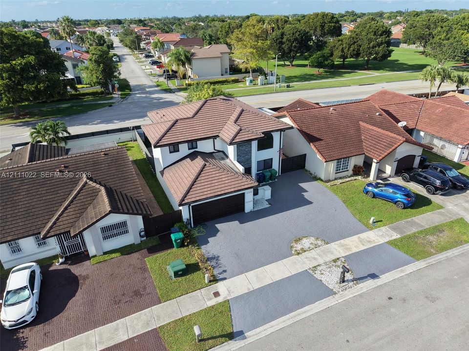 Two-story residence featuring a tile roof, stucco exterior, stone facade accents, and a paved driveway