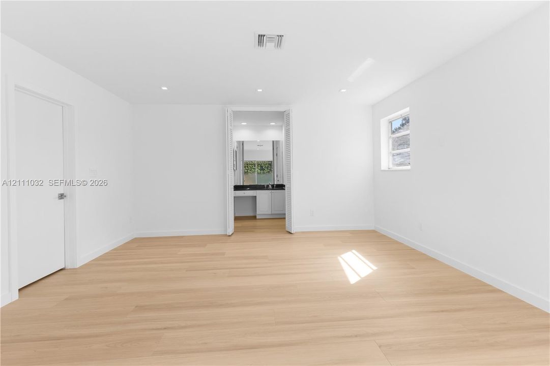 Interior space featuring wood-finish flooring, recessed lighting, and a single-pane window with white trim