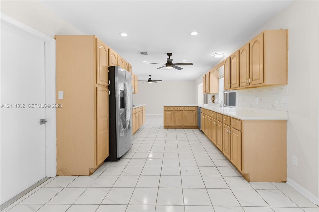 Kitchen featuring light-finish cabinetry, white countertops, ceramic tile flooring, recessed lighting, and dual ceiling fans