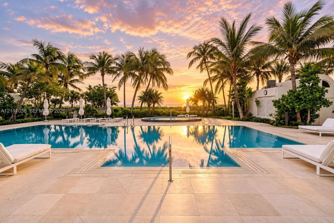 Swimming pool with a raised circular spa, expansive stone-paver pool deck, and mature palm tree landscaping