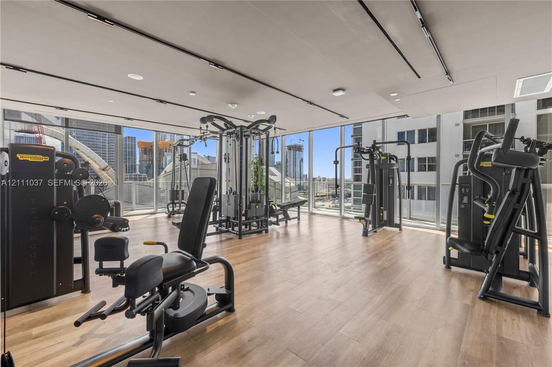 Fitness center featuring floor-to-ceiling windows, wood-finish flooring, and track lighting