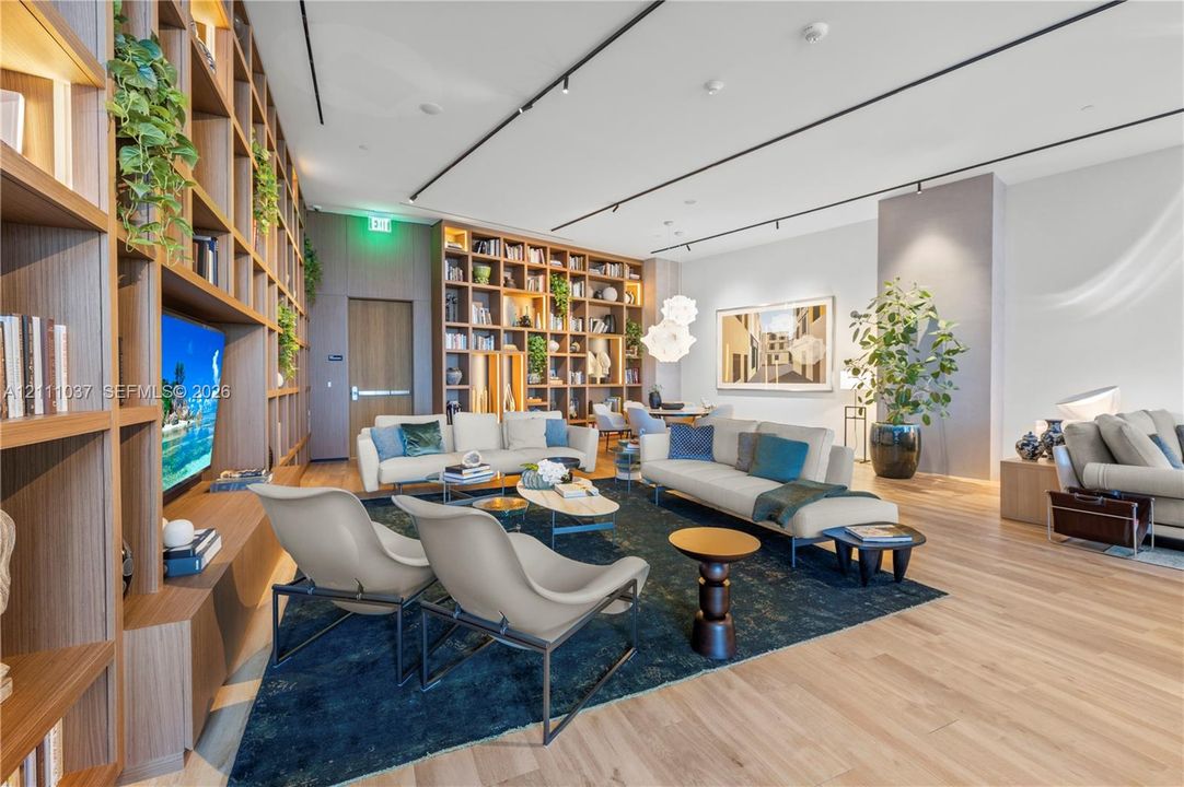 Expansive room featuring wall-to-wall built-in wood shelving, wood-finish flooring, and recessed track lighting