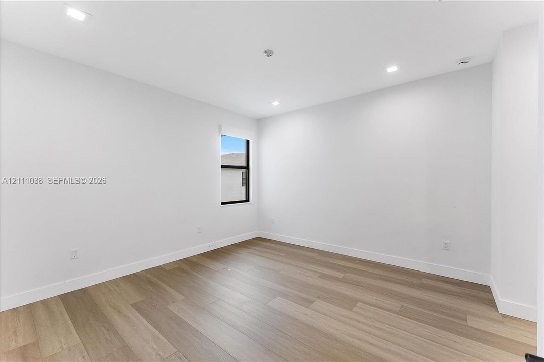 Interior space featuring wood-finish flooring, recessed lighting, and a window with a dark frame