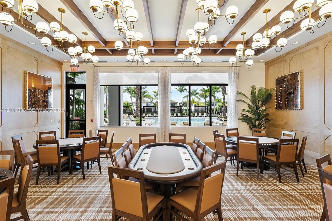 Wood-paneled wall treatments, coffered ceiling with exposed beams, and multiple oversized multi-globe chandeliers