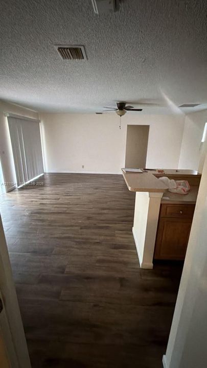 Wood-finish flooring, breakfast bar with cabinetry, and sliding glass patio doors
