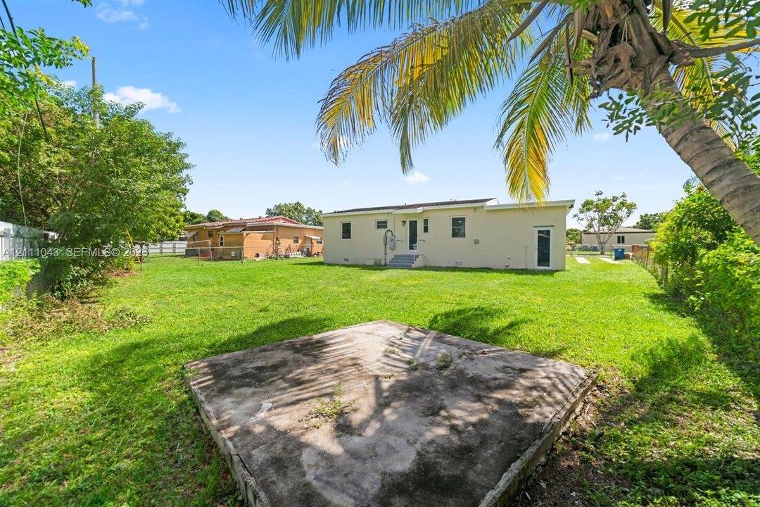 Expansive backyard featuring a large grass lawn, perimeter fencing