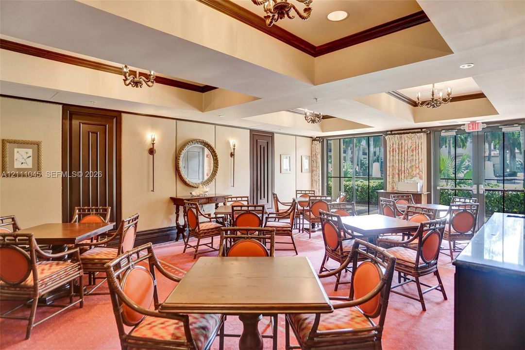 Tray ceiling with recessed lighting, panel-style wall detailing, floor-to-ceiling windows, and multiple built-in chandeliers
