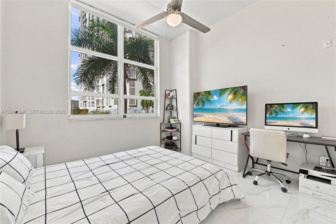 Large pane window featuring natural light, polished tile flooring, and a ceiling-mounted light fixture with fan blades
