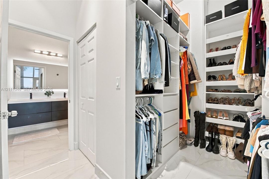 Custom walk-in closet featuring extensive built-in shelving, drawers, and hanging rods