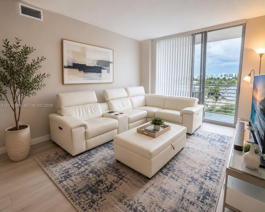 Living area featuring neutral wall paint, wood-finish flooring, and a glass sliding door providing exterior access