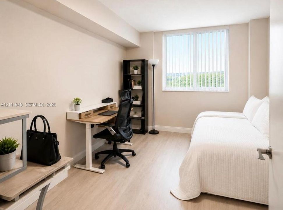 Neutral-toned room featuring wood-finish flooring, a large window with vertical blinds, and a smooth wall finish
