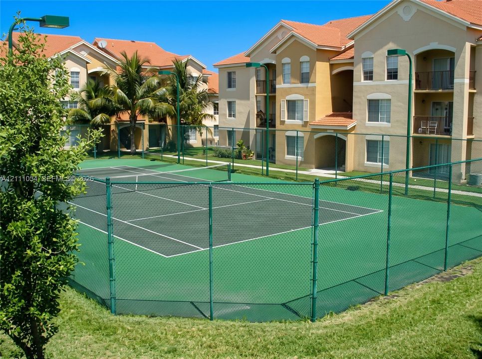 Tennis court with perimeter chain-link fencing, painted surface, and integrated net