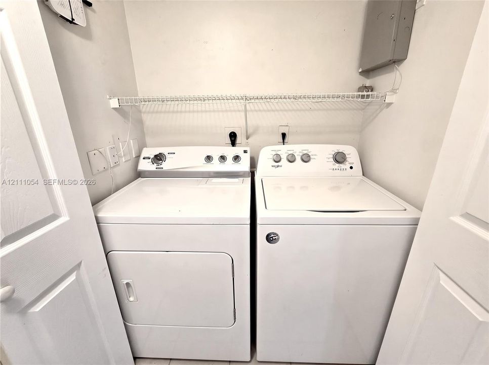 Laundry closet featuring built-in wire shelving and dual-hinged doors