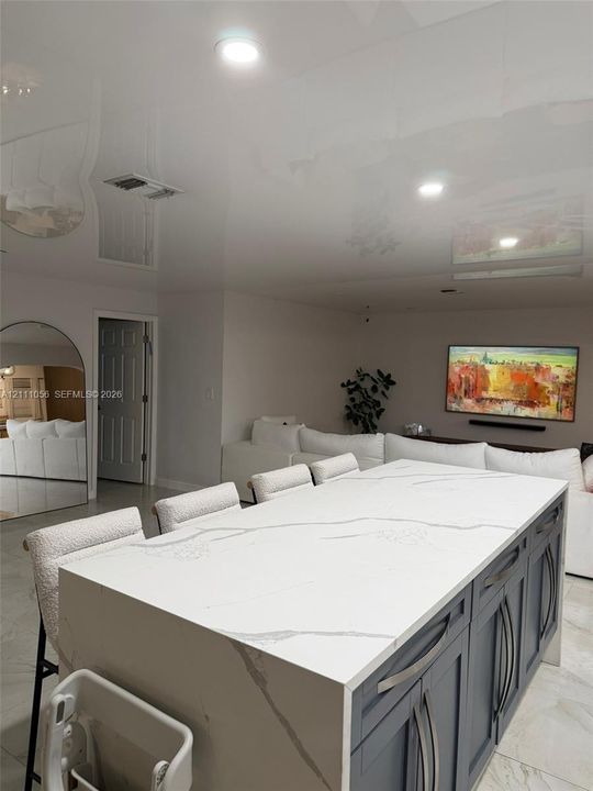 Floating vanity with wood-finish cabinetry, rectangular vessel sink, wall-mounted mirror, and chrome single-handle faucet