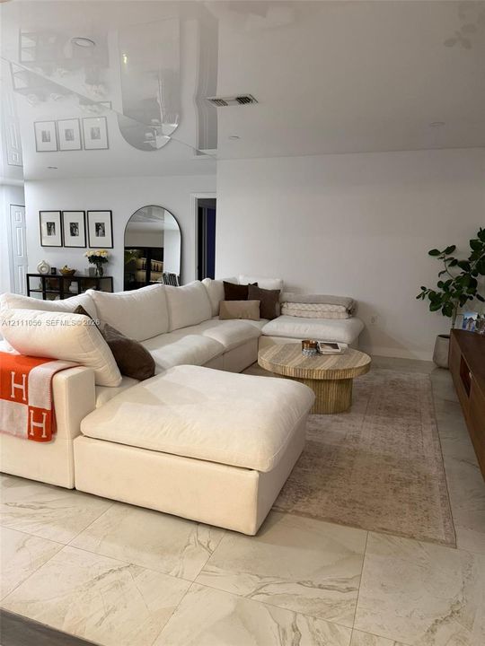 High-gloss reflective ceiling finish, expansive stone-finish tile flooring, and recessed lighting