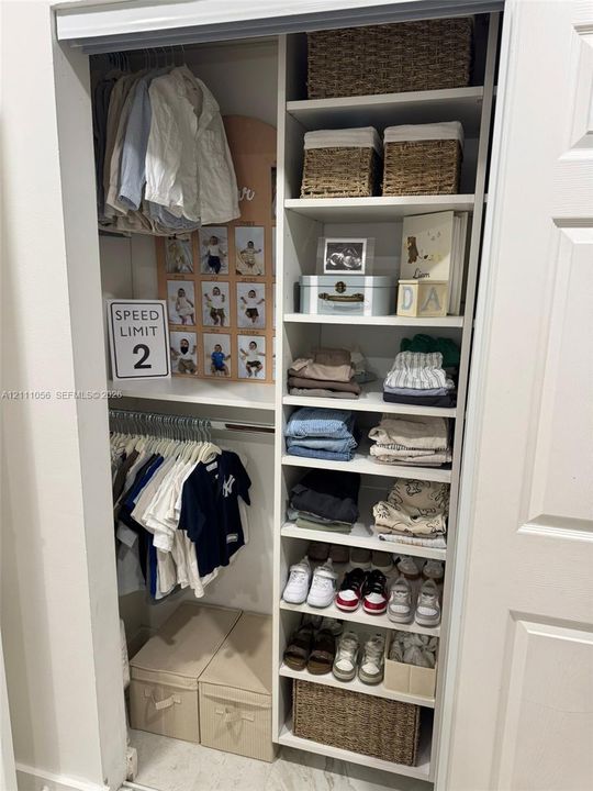 Built-in closet featuring dual hanging rods and an integrated shelving tower with fixed cabinetry