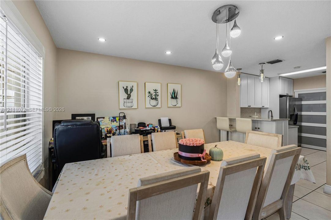 Dining area featuring tile flooring, multi-light pendant fixture, recessed lighting, and built-in breakfast bar