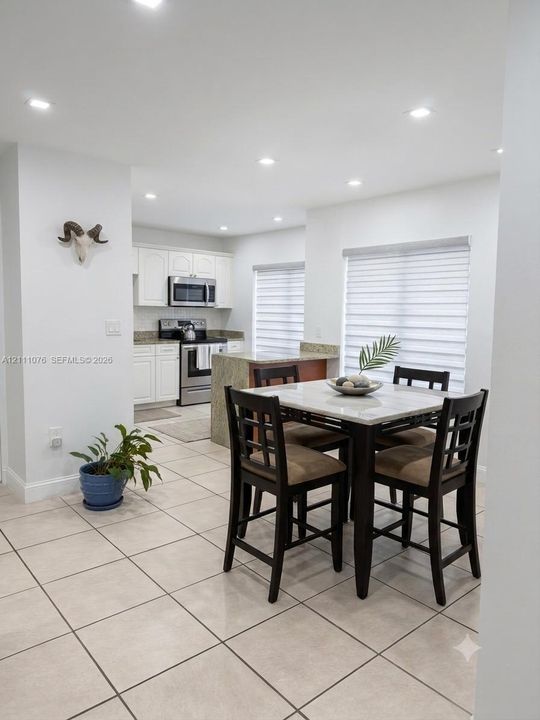 Kitchen featuring white cabinetry, stone-finish countertops, stainless steel appliances, recessed ceiling lighting, and ceramic tile flooring
