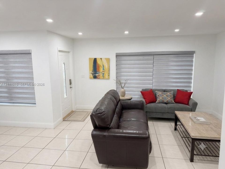 Neutral-toned ceramic tile flooring, recessed ceiling lighting, and multi-layered window shades