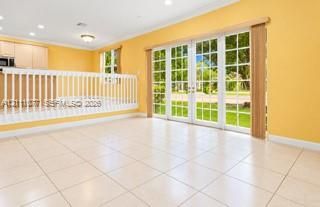 Tile flooring, multi-panel French glass doors, and white interior railings