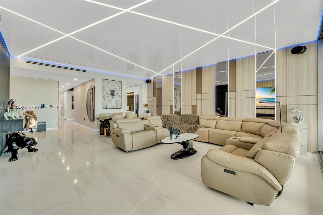 High-gloss ceiling featuring integrated linear LED lighting, polished stone-finish flooring, and vertical wood-paneled accent wall with inset mirrored panels