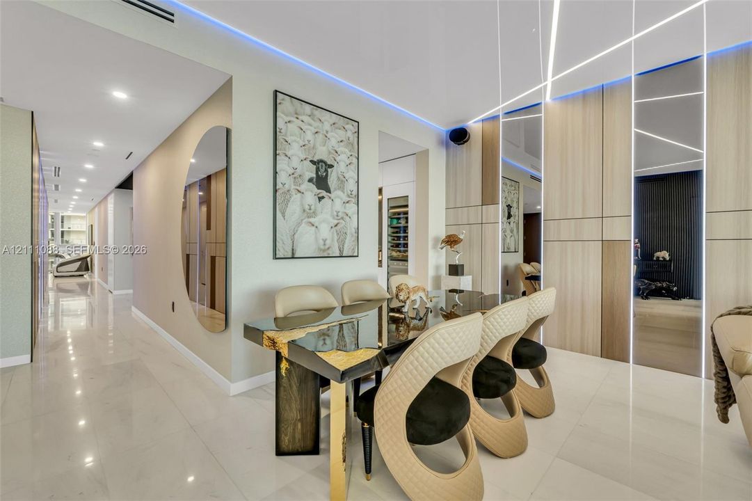 Large-format tile flooring, wood-finish paneled walls with integrated linear LED accent lighting, recessed ceiling lighting, and built-in climate-controlled wine storage
