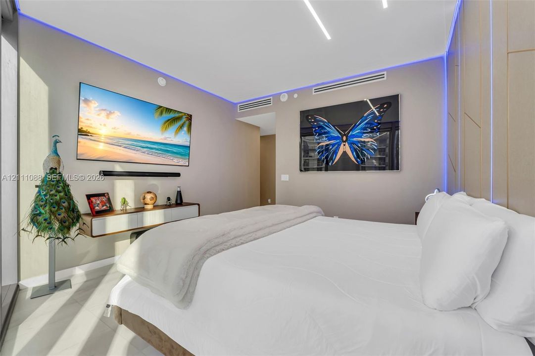 Interior space featuring recessed linear ceiling lighting, perimeter ambient cove lighting, tile flooring, and integrated wall paneling