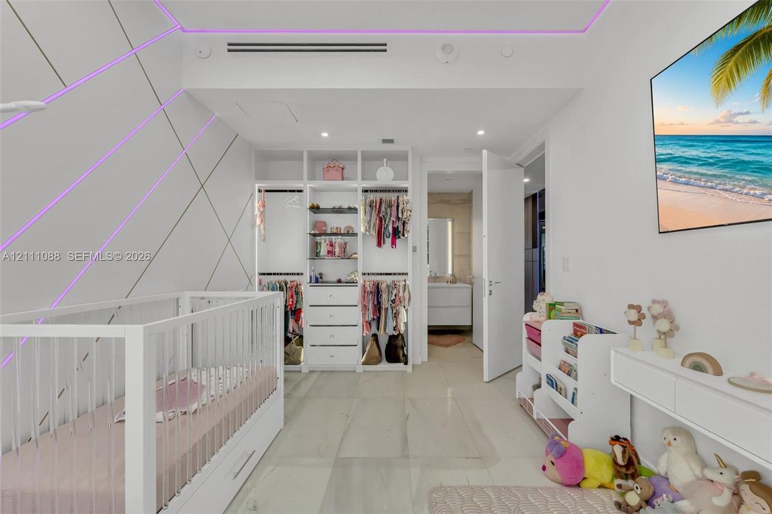 Custom built-in wardrobe with open shelving and integrated drawer storage, recessed LED accent lighting, and large-format tile flooring