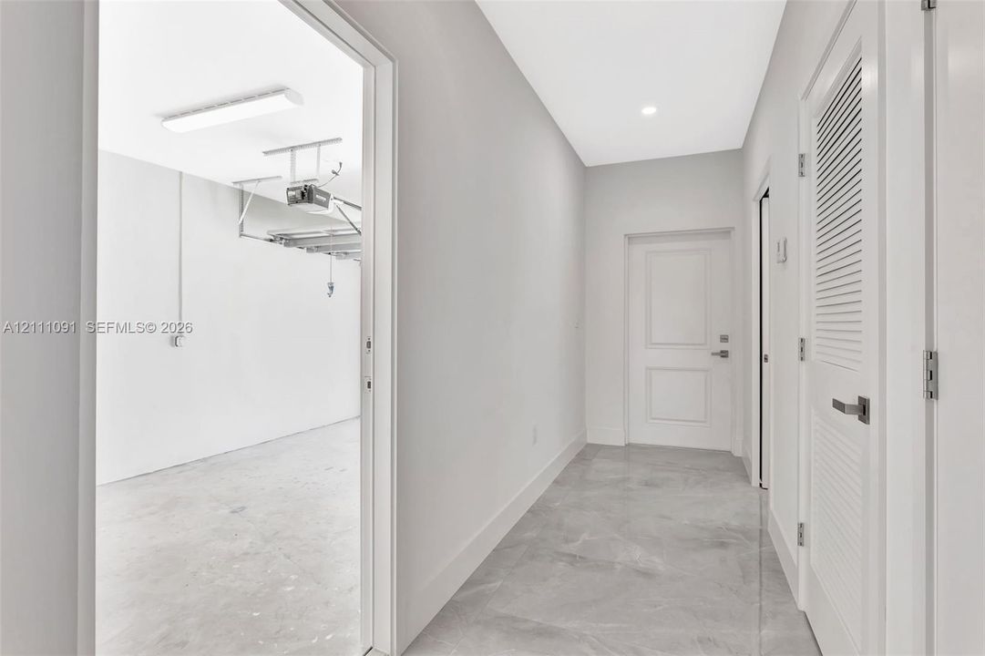 Neutral-toned tile flooring, solid-core interior doors, and a louvered mechanical closet door