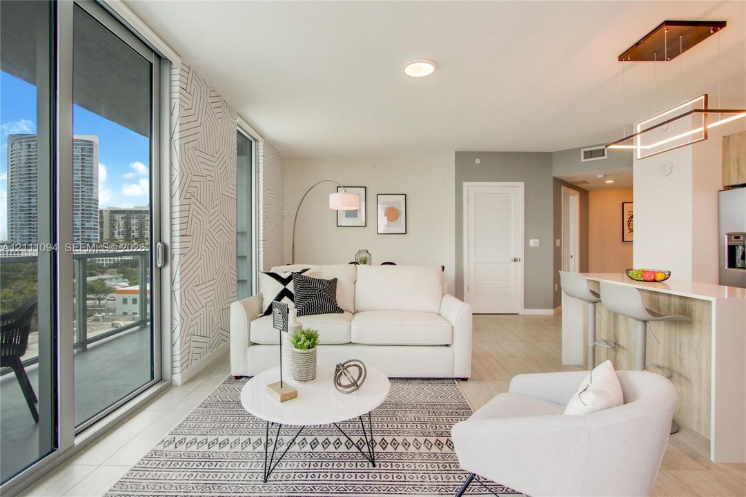 Open-concept interior featuring floor-to-ceiling glass sliding doors, textured geometric wall detailing, tile flooring, and a kitchen island with stone-finish countertop