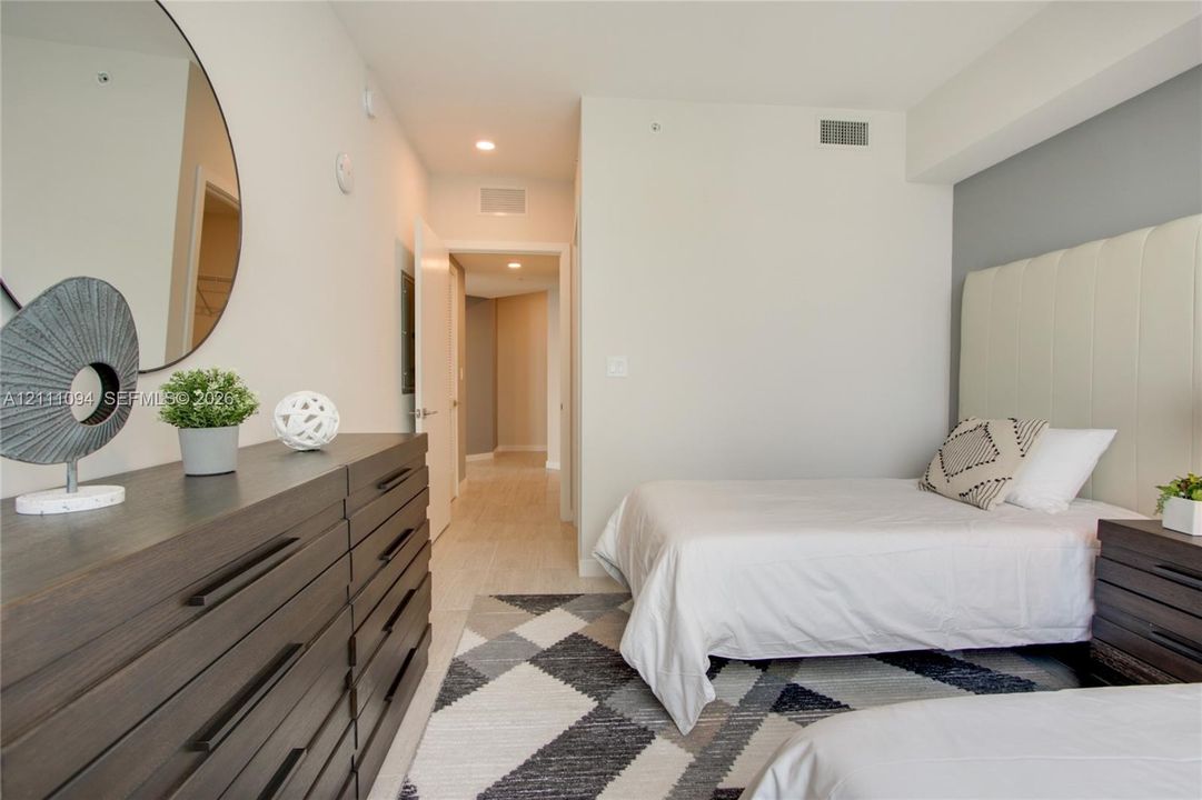 Neutral-toned interior featuring large-format tile flooring and an integrated wall-mounted headboard