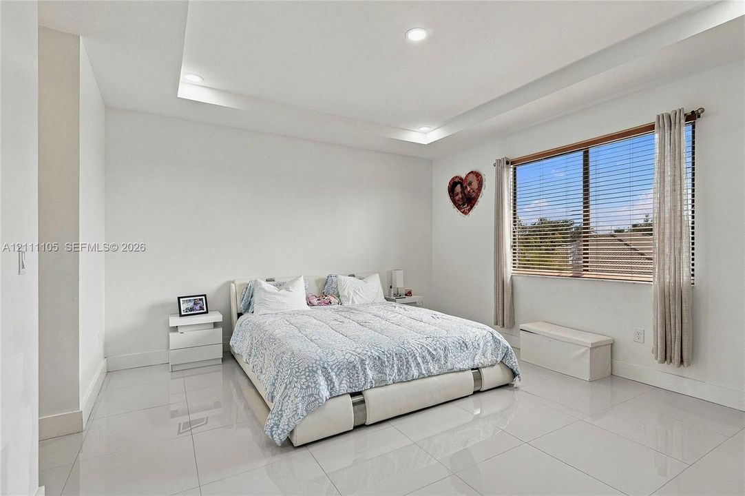 Tray ceiling featuring recessed lighting and large-format tile flooring