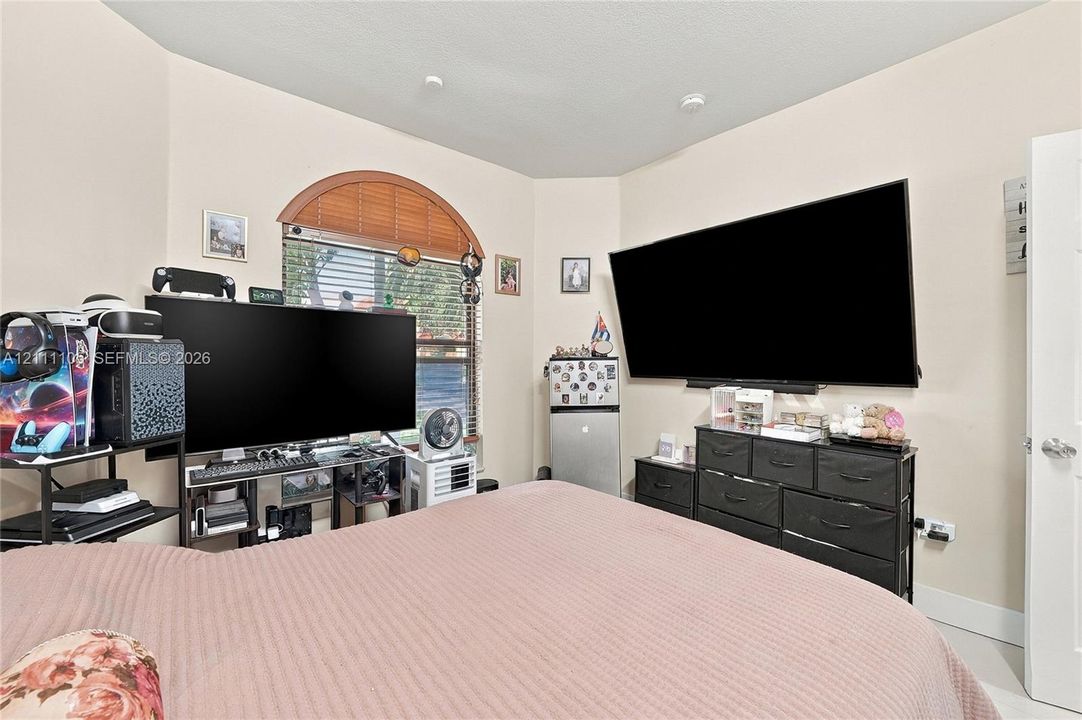 Room featuring a prominent arched window with horizontal blinds and neutral wall finishes
