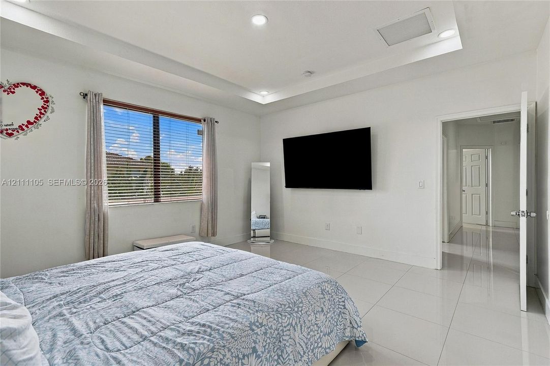 Tray ceiling with recessed lighting and large-format tile flooring