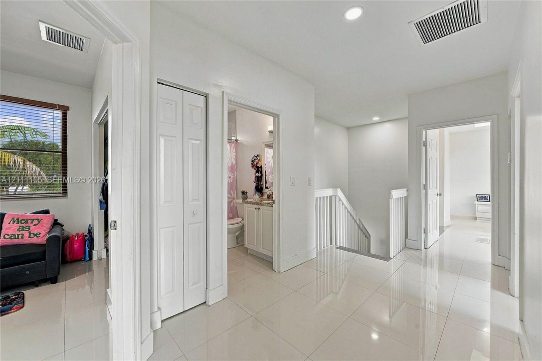 Interior space featuring large-format ceramic tile flooring, recessed lighting, and white bifold closet doors