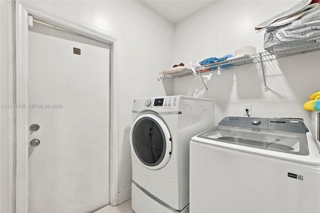 Laundry area featuring built-in wire shelving and a standard solid-core door